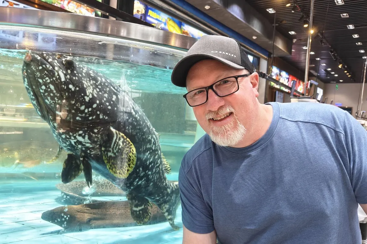 Josh with a grouper at a seafood market in China